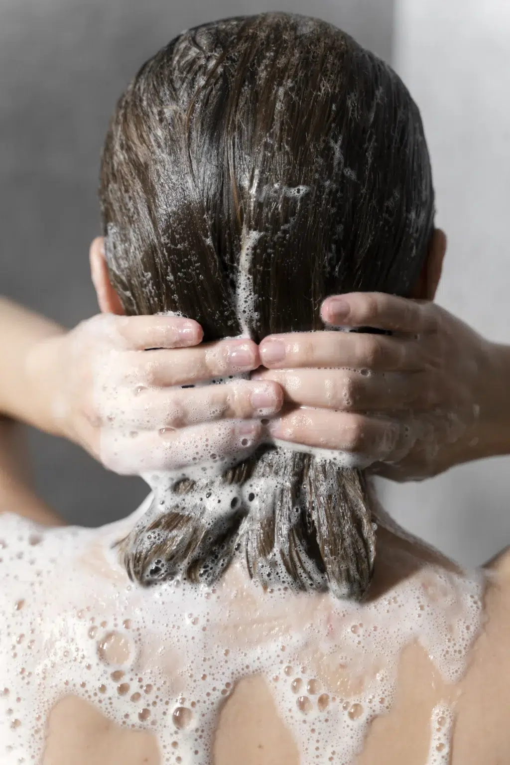 Kobieta myje włosy odpowiednio wybranym szamponem