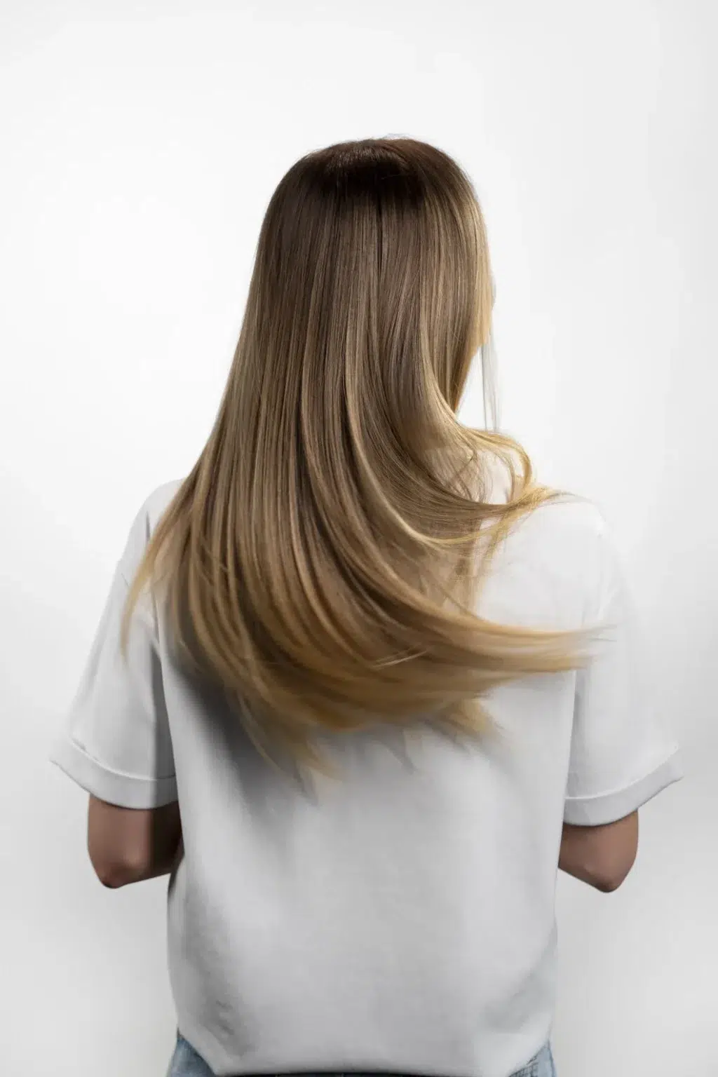Kobieta z długimi włosami po użyciu wcierki do włosów
